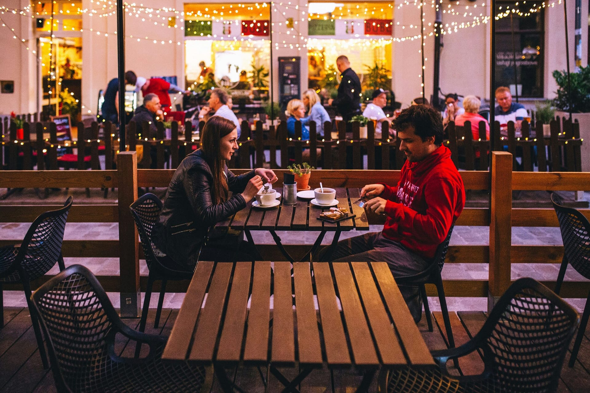 A man and woman on a date at an outdoor cafe, dating a divorced dad